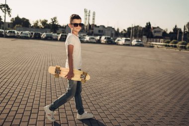 Sevimli küçük adam elinde kaykay ile