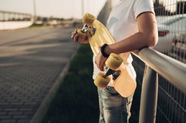 Sevimli küçük adam elinde kaykay ile