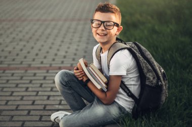 Beyaz T-Shirt ve kot kitapların elinde tutan küçük bir çocuk portresi