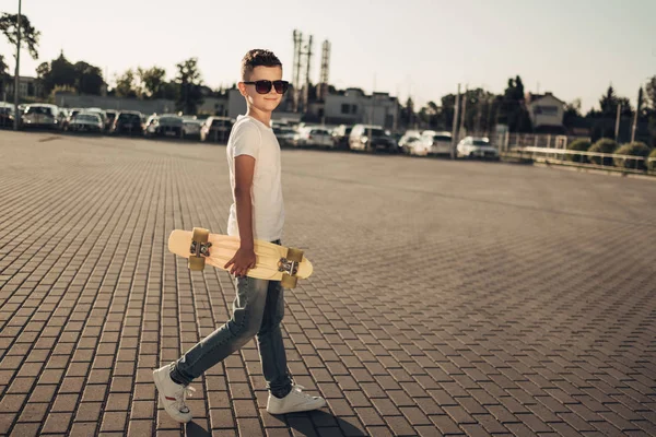 Sevimli küçük adam elinde kaykay ile