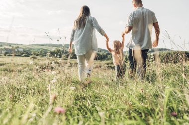 Üç kişi yaz zevk aile hafta sonu piknik kavramı, şehir dışında parkta eğleniyor onların küçük kızı ile genç yetişkin çift