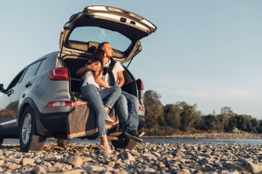 Mutlu çift Roadtrip Suv arabada batımına üzerinde