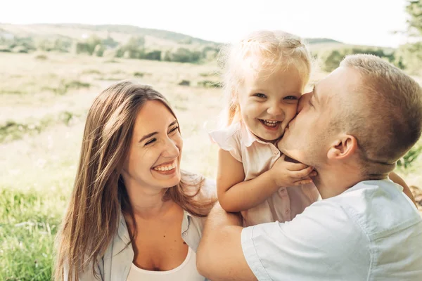 Üç kişi yaz zevk aile hafta sonu piknik kavramı, şehir dışında parkta eğleniyor onların küçük kızı ile genç yetişkin çift