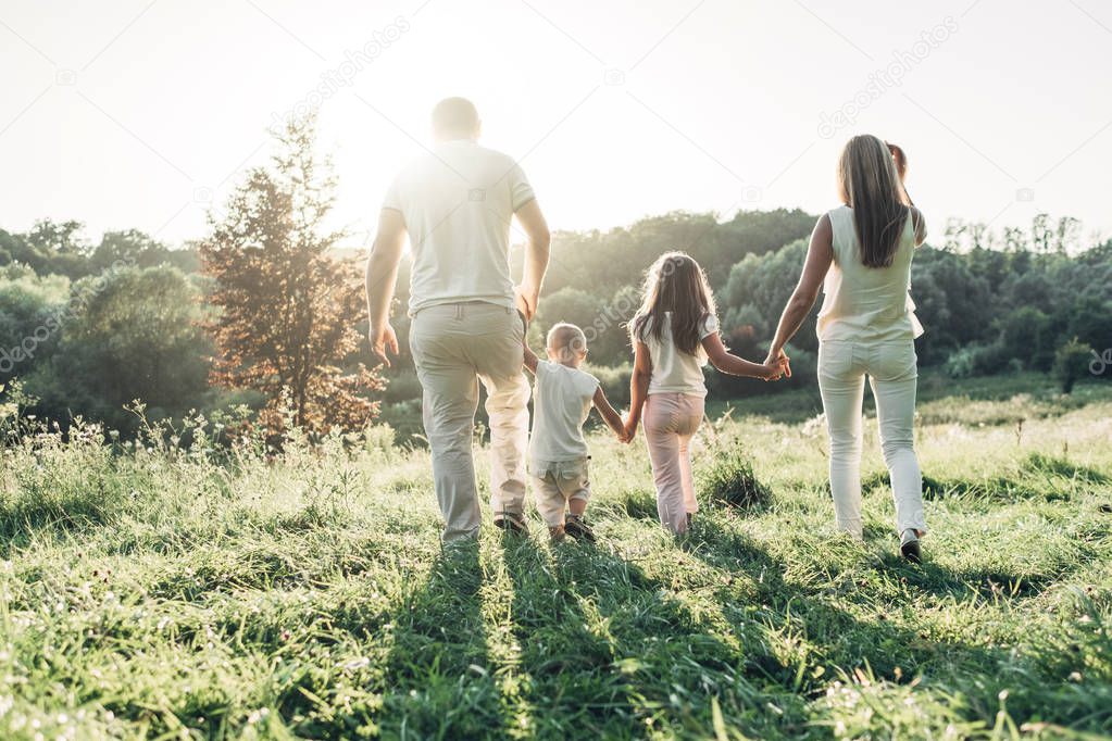 Adult couple with their little children having picnic in the Park Outside the City, Family Weekend Concept, Four People Enjoying Summer