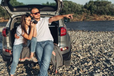 Mutlu çift Roadtrip Suv arabada batımına üzerinde