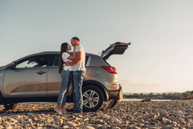 Mutlu çift Roadtrip Suv arabada batımına üzerinde