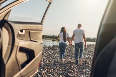 Mutlu çift Roadtrip Suv arabada batımına üzerinde