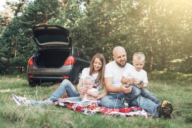 Piknik ormanda, Aile hafta sonu kavramı, dört kişi yaz zevk küçük çocukları ile birlikte genç çift