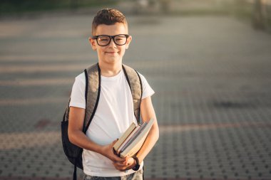 Beyaz T-Shirt ve kot kitapların elinde tutan küçük bir çocuk portresi