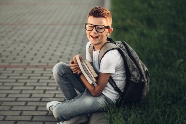 Beyaz T-Shirt ve kot kitapların elinde tutan küçük bir çocuk portresi