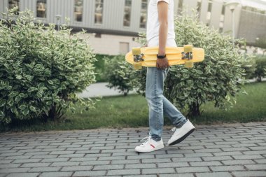 Sevimli küçük adam elinde kaykay ile