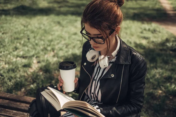 Outdoor Summer Portrait of Young Beautiful Girl in Black Leather Jacket Leads Livro no Parque — Fotografia de Stock