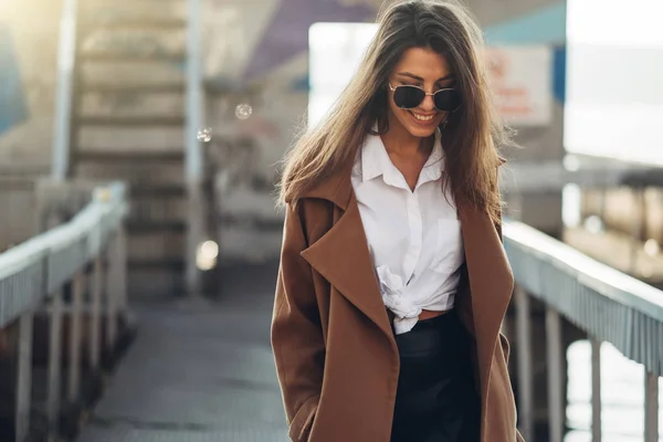 Gün batımında Bahar Plajı'nda Yürüyen Paltolu Güzel Genç Şık Kız