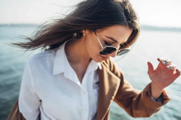 Menina bonita e elegante em casaco Caminhando na praia da primavera ao pôr do sol — Fotografia de Stock