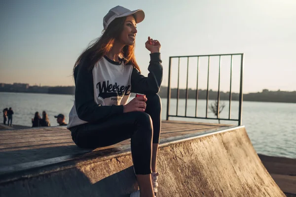 Mooie jonge hipster meisje in pullover met tekst "weekend Forever" wandelen in het strand bij zonsondergang — Stockfoto