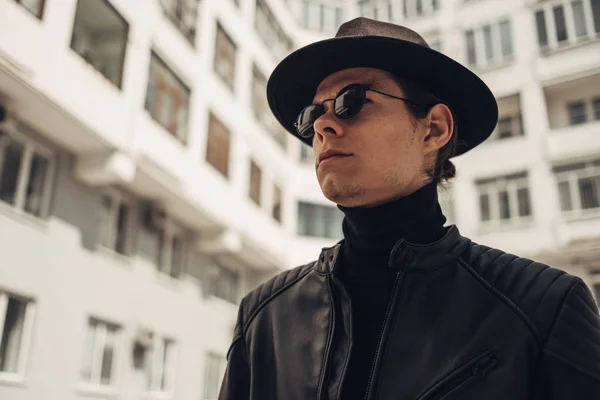 黒いレザージャケットと帽子のスタイリッシュな若者の肖像 — ストック写真