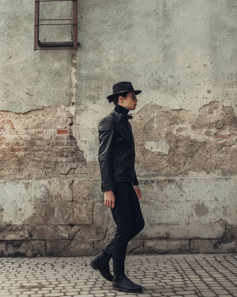 Retrato de jovem elegante em jaqueta de couro preto e chapéu — Fotografia de Stock