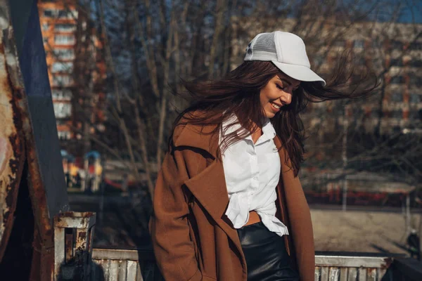 Bella giovane ragazza elegante in cappotto a piedi nella spiaggia di primavera al tramonto — Foto Stock