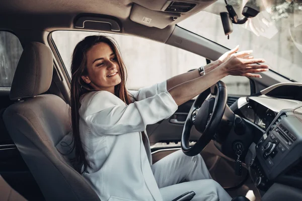 Moda elegante conductor chica en traje blanco sentado en el coche — Foto de Stock
