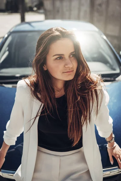 Retrato de moda elegante menina de terno branco posando perto do carro azul — Fotografia de Stock