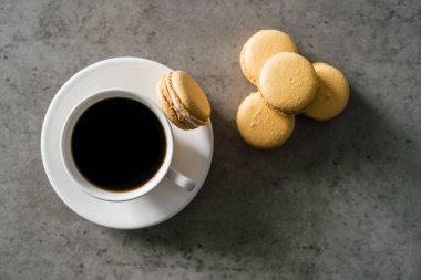 Bir avuç dolusu leziz sarı Fransız Makarnası ve bir fincan kahve.