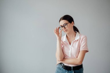 Gözlüklü, Pembe tişörtlü, Kameraya poz veren Genç Yetişkin Güzel Kızın Stüdyo Portresi