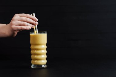 Bir Sarı Meyve Smoothie Kokteyli Kara Masa 'da duruyor.