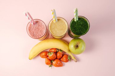 Üç Farklı Renkli Meyve Smoothie Kokteyli Pembe Arkaplanda Bir avuç Meyve Duruşu