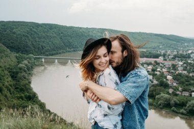 Genç Moda Gezgini Çift Tepenin Üzerinde Eğleniyor Nehir kenarındaki Vadi 'de Günbatımının tadını çıkarıyor Seyahat ve Yürüyüş Gezisi Konsepti