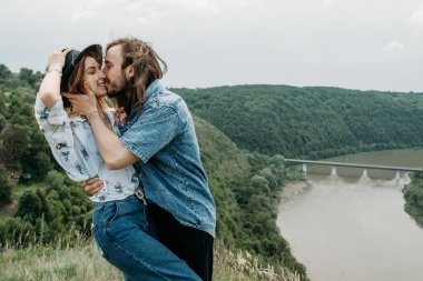Genç Moda Gezgini Çift Tepenin Üzerinde Eğleniyor Nehir kenarındaki Vadi 'de Günbatımının tadını çıkarıyor Seyahat ve Yürüyüş Gezisi Konsepti