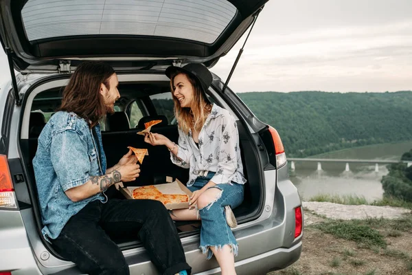 Joven Elegante Viaja Hipsters Divirtiéndose Sentado Maletero Del Coche Comiendo —  Fotos de Stock