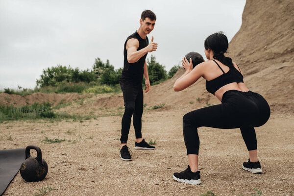 Два спортсмена в черном спорте вместе тренируются под открытым небом
