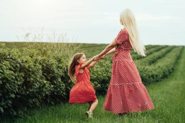 Genç Anne, Kırmızı Polka Dot Elbisesi Giymiş Küçük Kızıyla Şehrin Dışında Eğleniyor, Annelik ve Çocukluk Konsepti