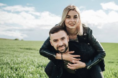 Siyah Deri ve Kot Ceketli Mutlu Genç Çift Yeşil Tarlada Eğleniyor