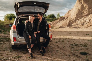 Siyah Deri ve Kot Ceket Giymiş Mutlu Genç Gezgin Çifti Şehir dışında Gezintide Eğleniyor