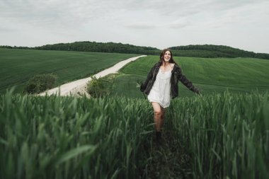 Beyaz Elbiseli Genç Tarz Kızı ve Denim Ceketi Yeşil Buğday Tarlasında Zaman Geçiriyor