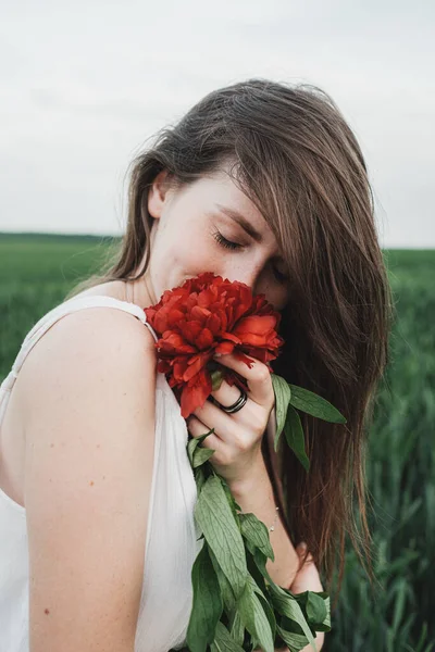 白いドレスの若い美しい少女の肖像画を閉じる赤い牡丹の花束を保持 — ストック写真
