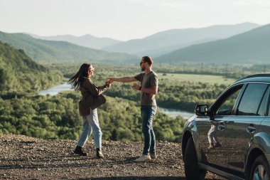 Genç Gezgin Çift Yolculukta, Erkek ve Kadın Güzel Manzara Üzerinde Arabalarıyla Keyifli Yolculuk Ediyor