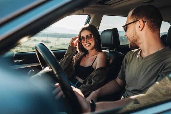 Young Couple on Road Trip, Man Diving Car with Woman Sitting on Passenger Seat