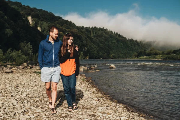Young Couple Enjoying Weekend Outdoors by River