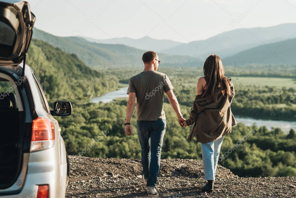 Young Traveler Couple on Road Trip, Man and Woman Enjoying Journey on Their Car Over Beautiful Landscape