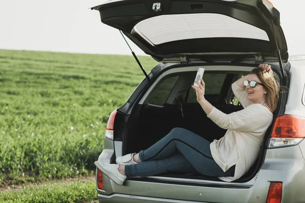 Açık Arabada Oturan Genç Kadın Smartphone 'da Selfie Çekiyor