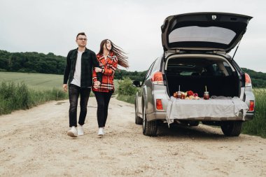 Genç ve güzel bir çift, Araba, Seyahat ve Yolculuk Konsepti 'nin yanında eğleniyor.