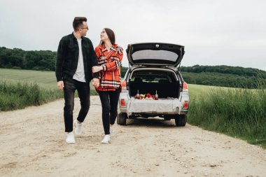 Genç ve güzel bir çift, Araba, Seyahat ve Yolculuk Konsepti 'nin yanında eğleniyor.