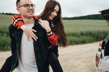 Genç ve güzel bir çift, Araba, Seyahat ve Yolculuk Konsepti 'nin yanında eğleniyor.