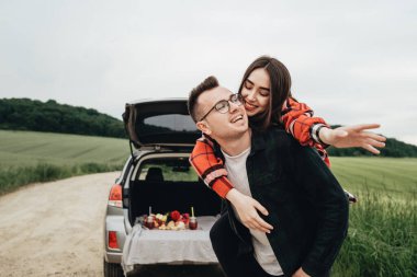 Genç ve güzel bir çift, Araba, Seyahat ve Yolculuk Konsepti 'nin yanında eğleniyor.