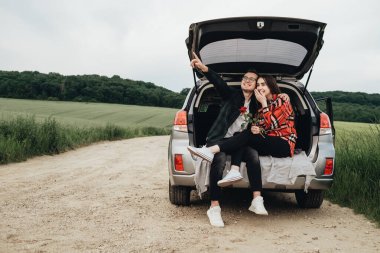 Genç ve Güzel Çift Araba Gövdesinde Oturuyor ve Yolculuğun Tadını Çıkartıyor, Gül Tutan Kız, Romantik Ruh Hali