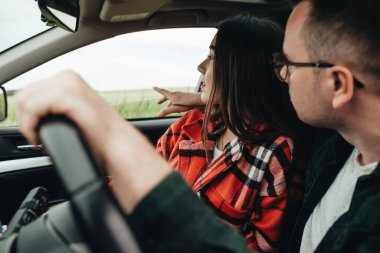 Genç ve güzel bir çift arabada oturuyor ve yolculuğun tadını çıkarıyor.