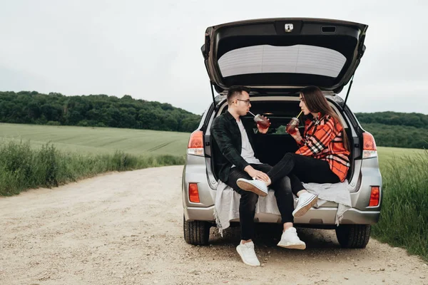 Young Beautiful Couple Sitting Car Trunk Enjoying Roadtrip Picnic Concept — Stock Photo, Image