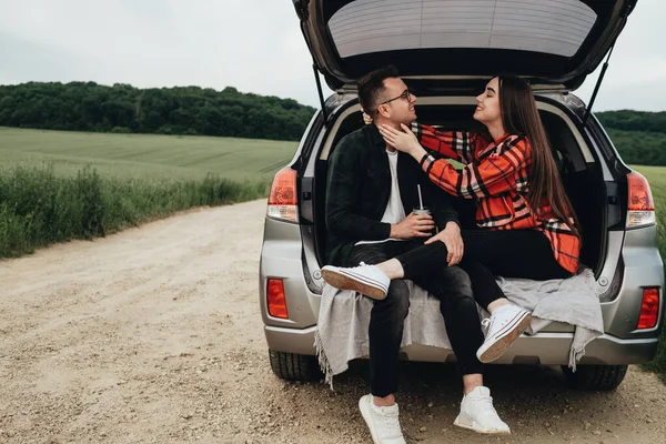 Genç Güzel Bir Çift Araba Bagajında Oturuyor Yolculuğun Tadını Çıkarıyor — Stok fotoğraf